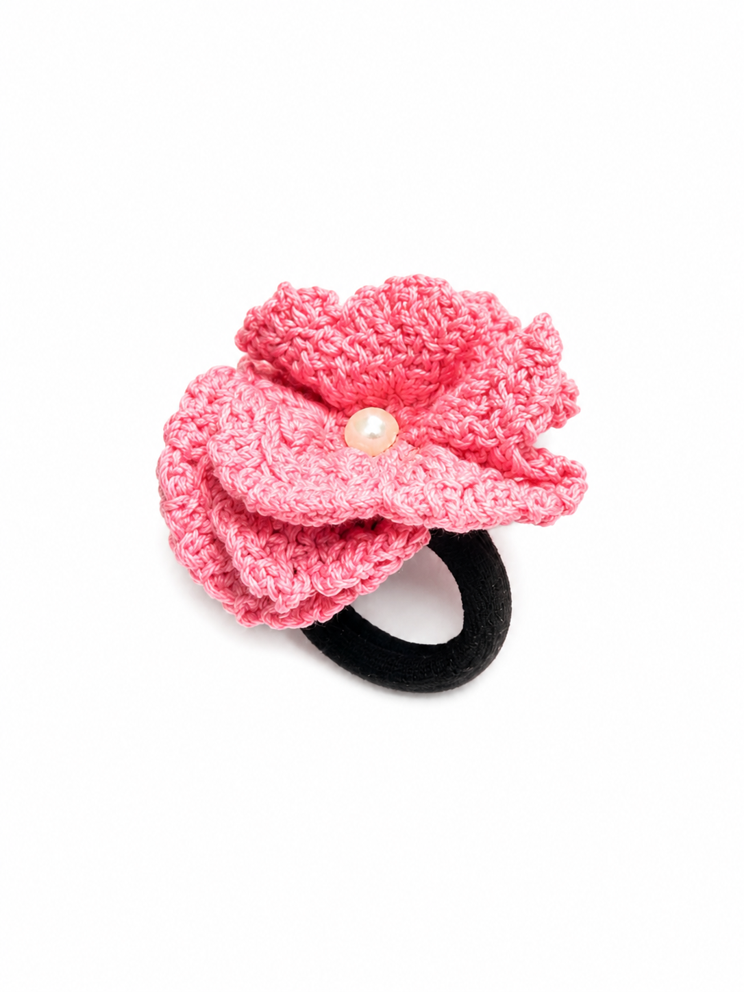 A pink crocheted flower hair clip with a black elastic band and a small pearl-like center, shown on a plain white background.