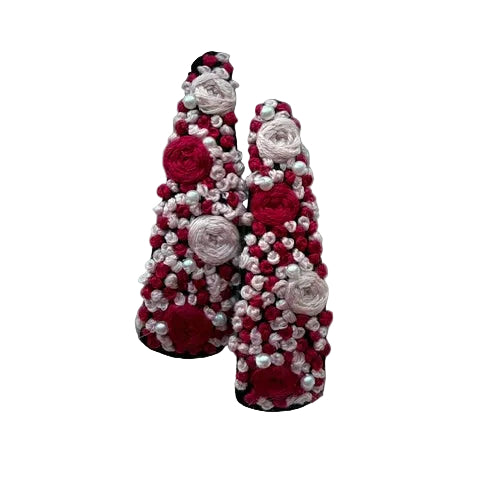 A pair of pointed-toe flats decorated with red and pink yarn roses and white faux pearls, displayed on a white faux fur background.
